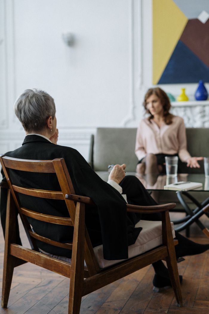 A therapist and patient engaged in a counseling session in a modern office setting.